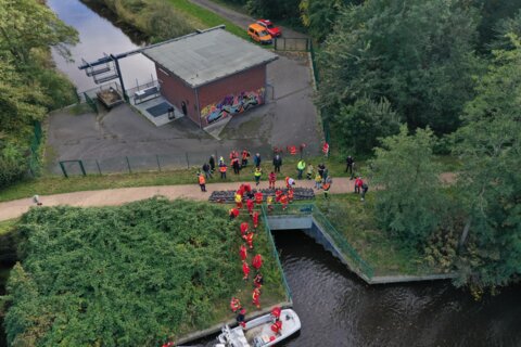 Aerial view of the human chain. The emergency services transport sandbags from land onto a boat.